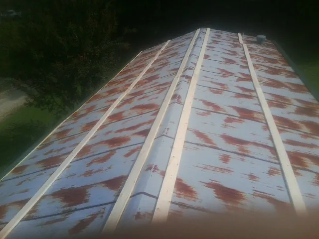 Rusted metal roof panels with new wood purlins before replacement — Storm Damage Roof Repair in Zion by Roofing Brothers