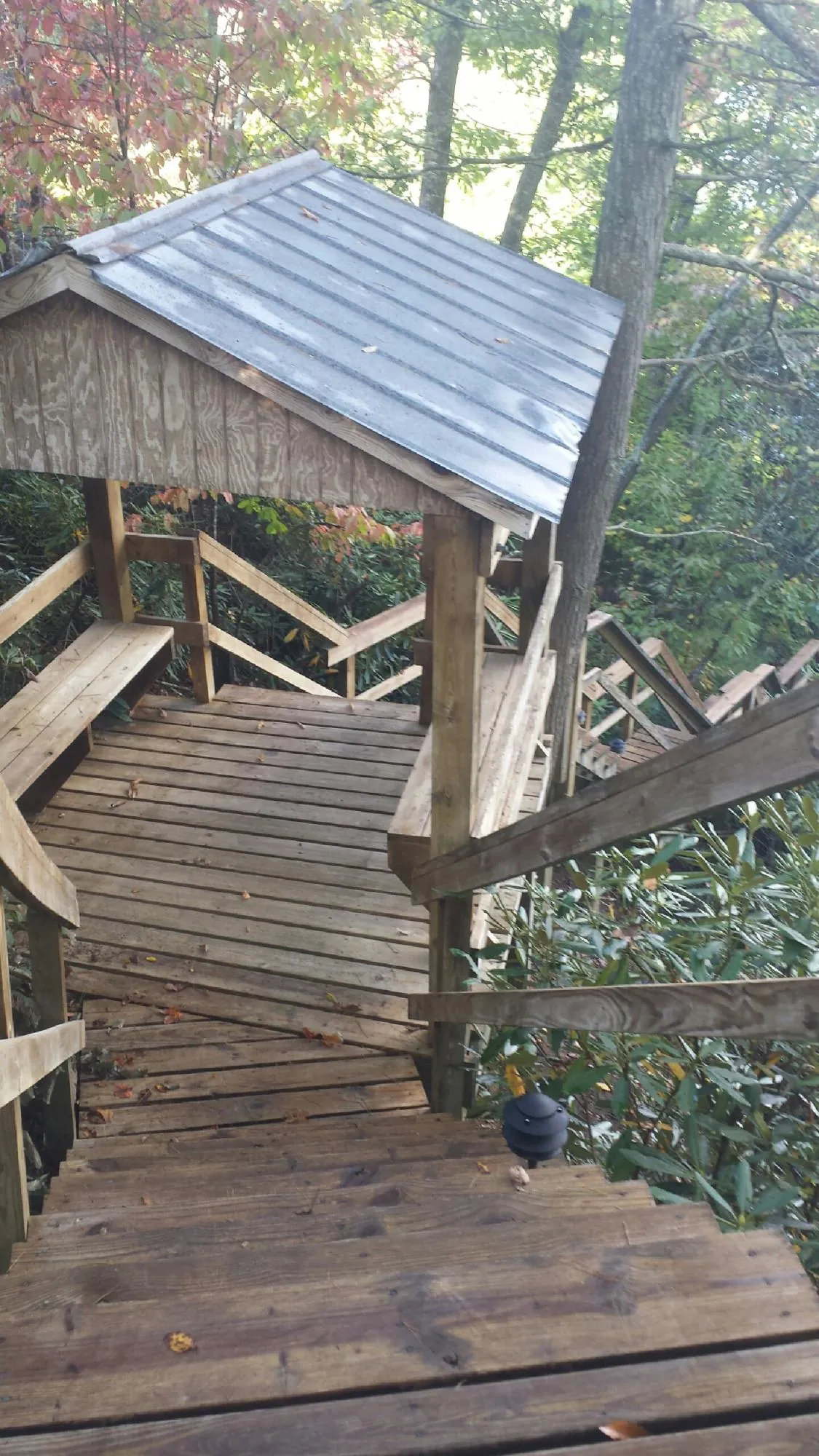Metal roofed shelter over wooden steps on a wooded walkway — Skylight Repair & Installation work by our crew in Zion
