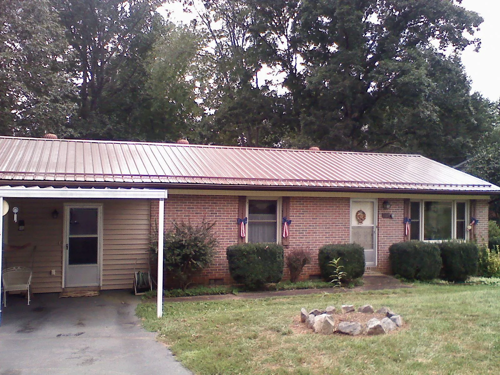 Bronze metal roof and carport on a brick ranch home — Roof Repair work by our crew in Zion